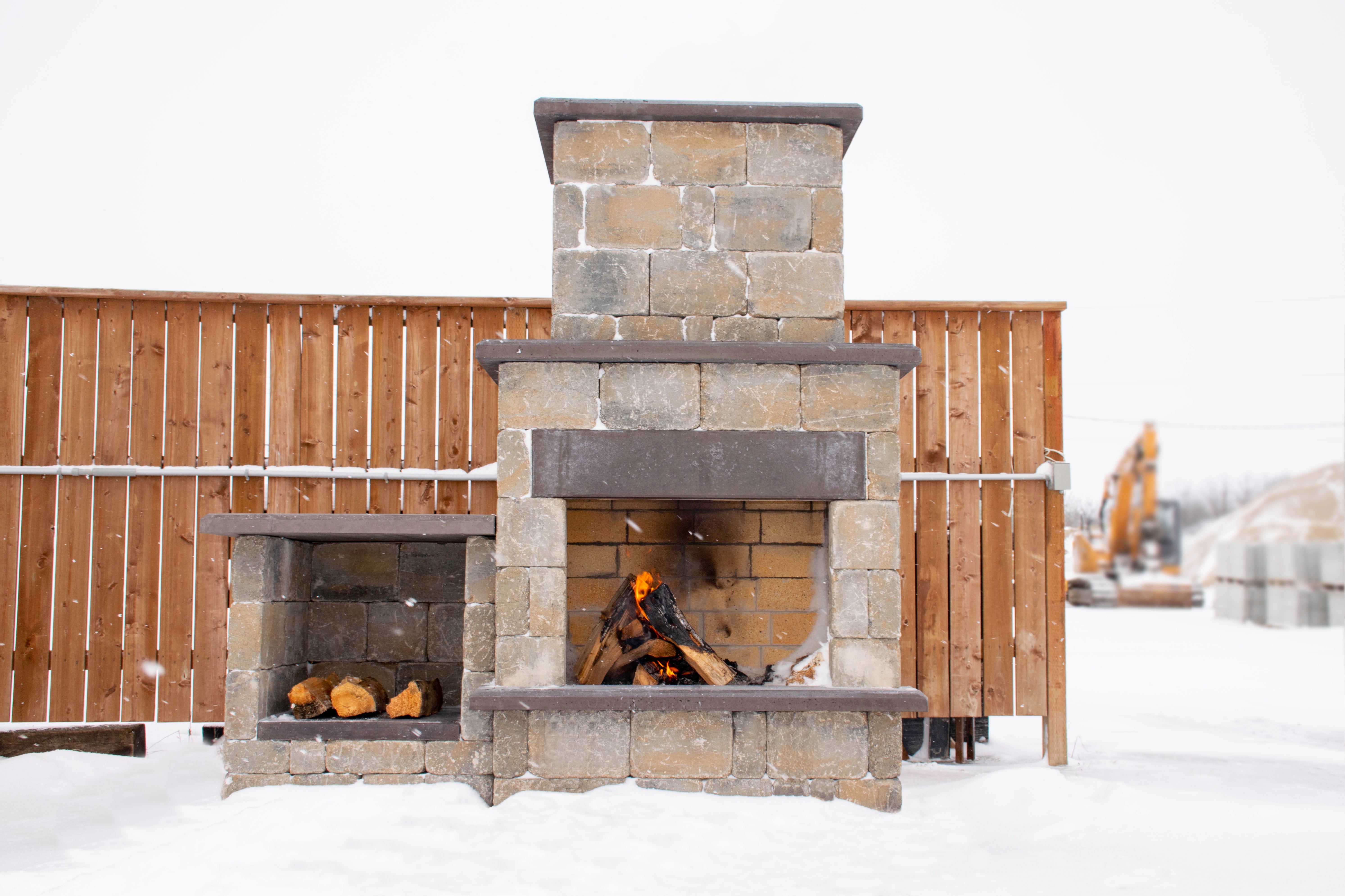 Rustic Lakeside Fire Place Product Photo 1 Rustic Lakeside Fire Place with a wood box with a small fire in the snow.