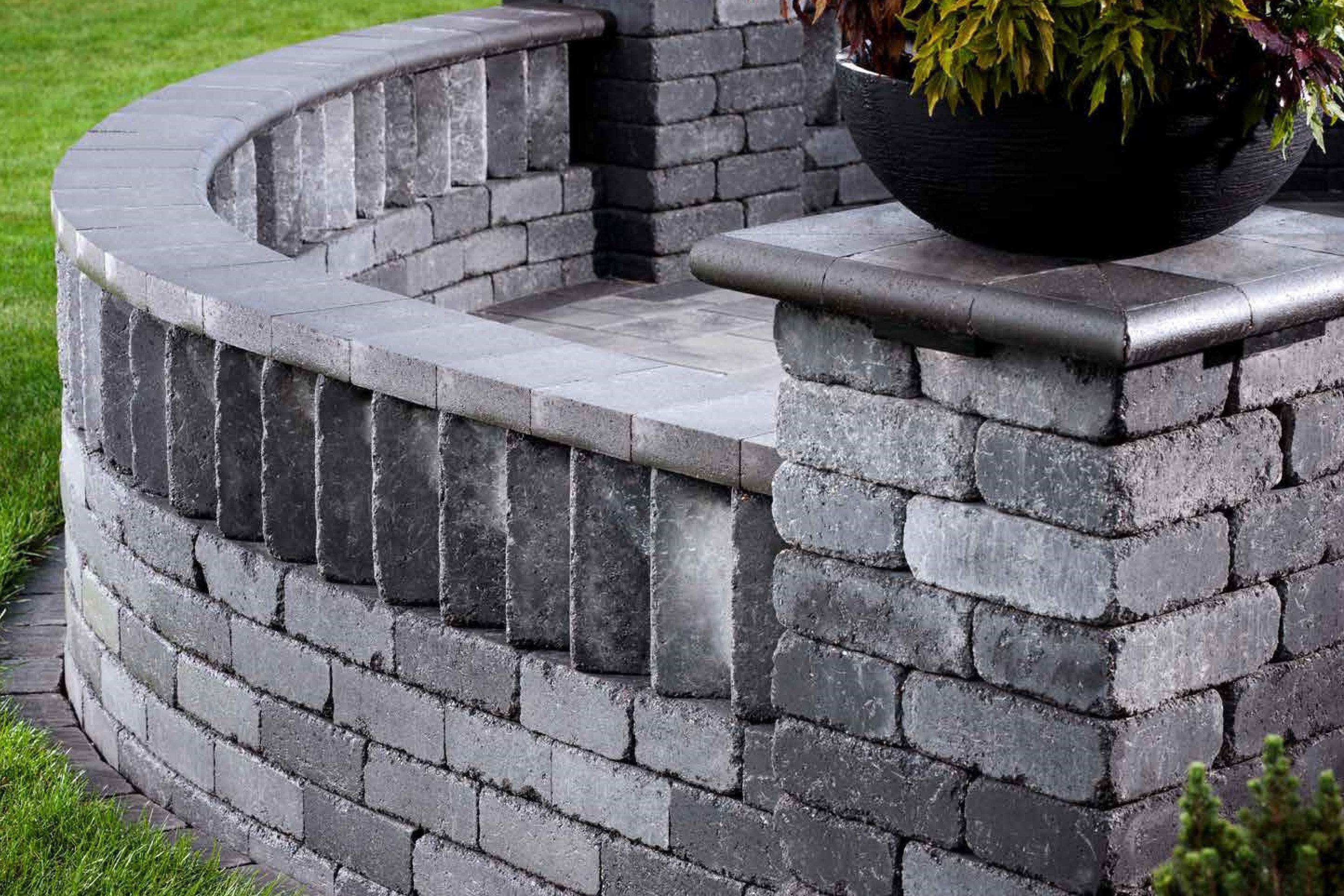 Weston Wall Corner Product Photo Rounded retaining wall with a unique cap stone design and pillars made with Weston Wall Corner Bricks