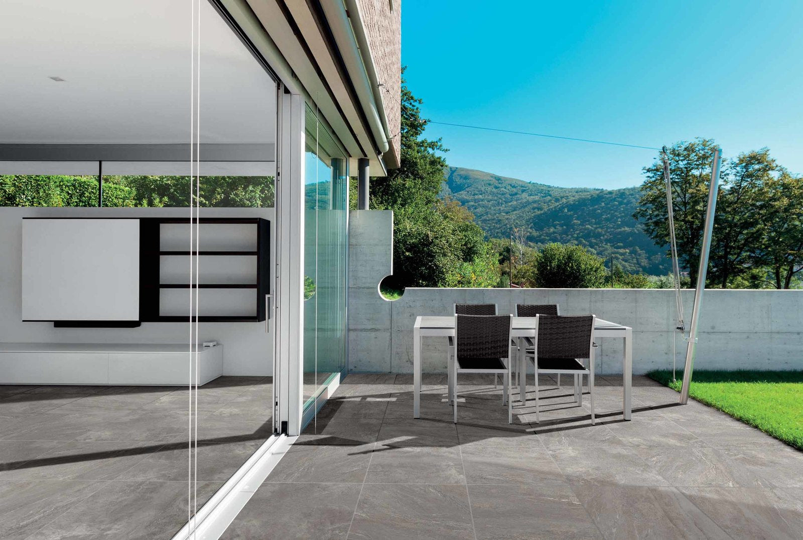 luxury patio installed with porcelain pavers with hills rolling in the background.