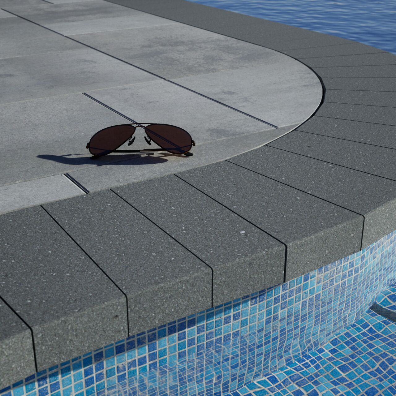 Delmaro Coping installed around a pool with a pair of sunglasses.