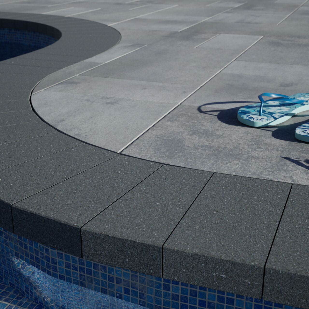 Delmaro Coping installed around a pool edger with a pair of flip flops.