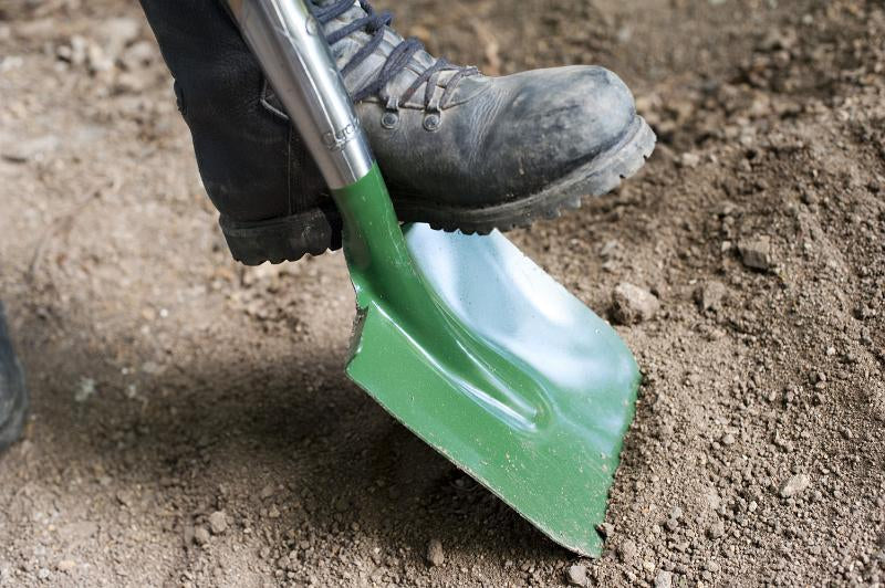 a shovel being used to excavate an area for a patio.