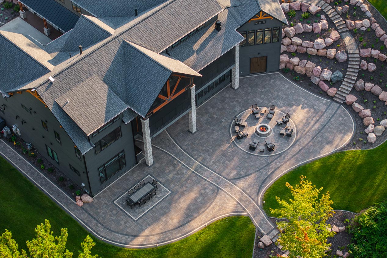 Birds eye view of a luxury patio with a dining area, a fire pit area and staircase.