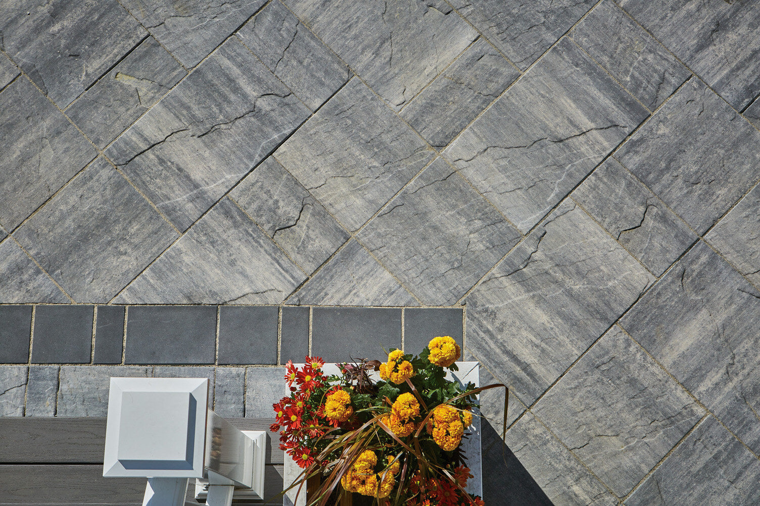 Close up of a patio installed with Grand Tranquility Pavers in the colour Majestic