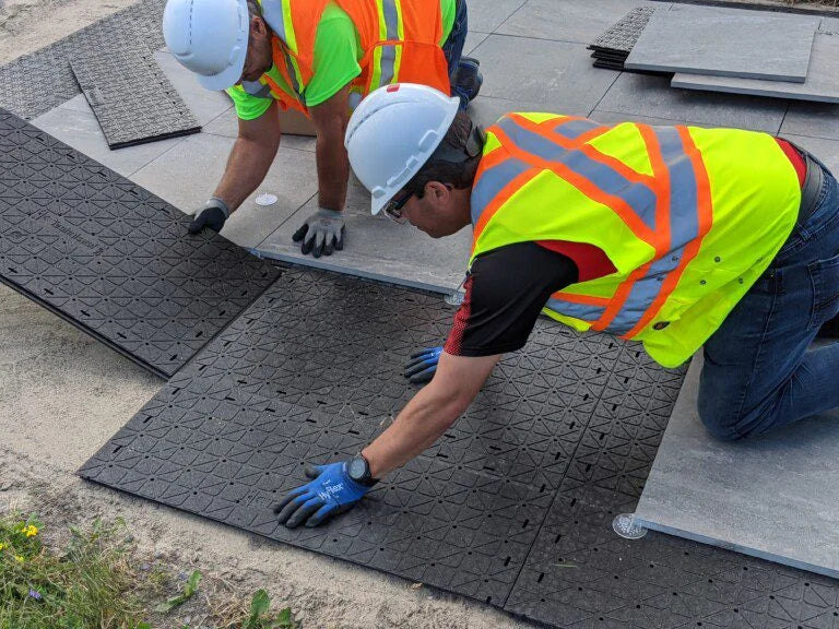 Contractors installing Next Base and Porcelain pavers for a patio.