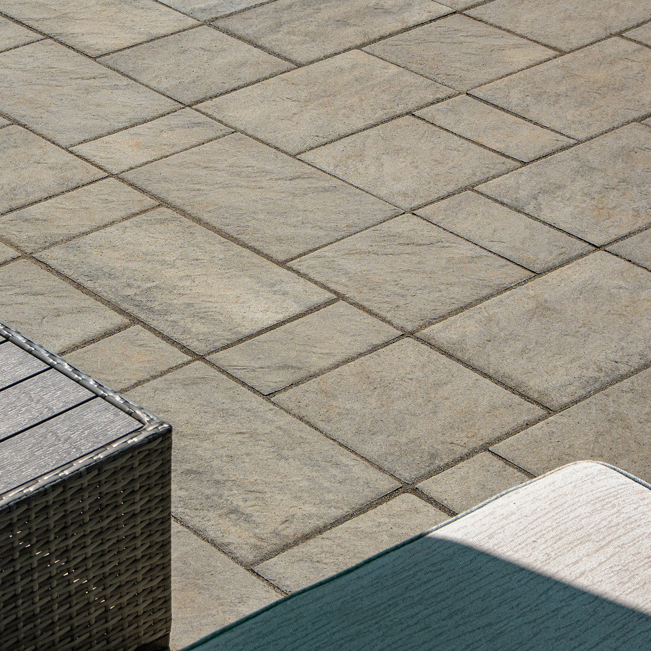 Close up of a patio installed with Trilogy+ Textured Pavers.