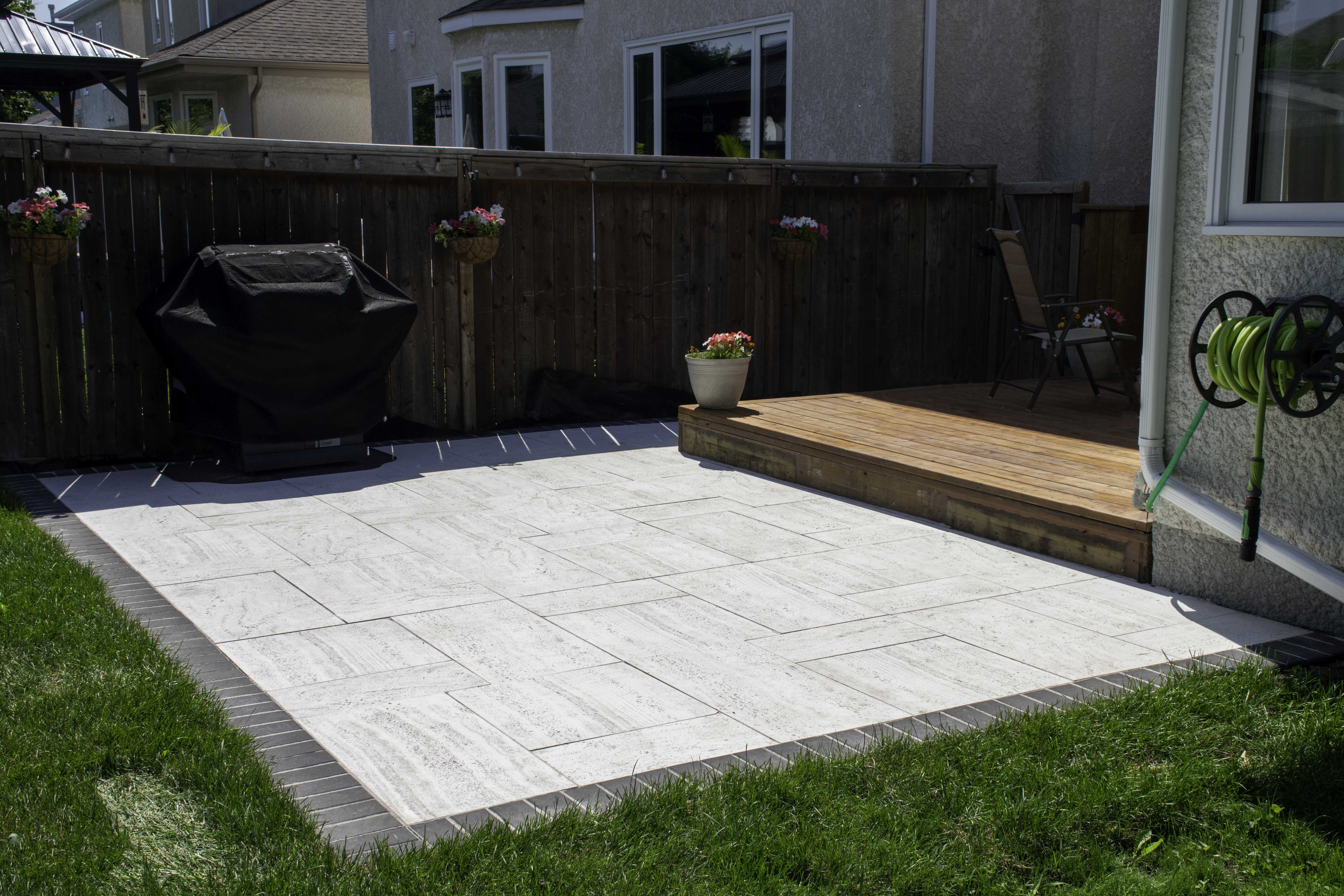 Simple Backyard patio installed using Travertine paver set in the colour Dover
