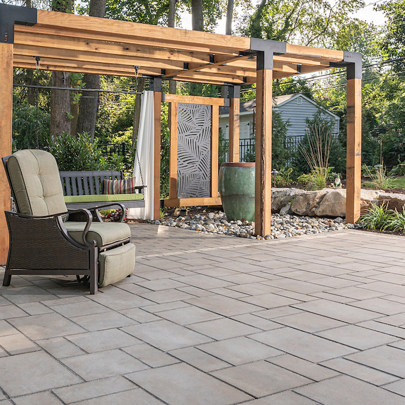 Luxury Patio with a chair and pergola installed with Trilogy+ Smooth Pavers