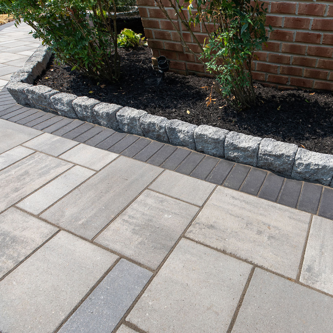 Close up in the edge of a patio installed with Trilogy+ Smooth Pavers, Holland Pavers and edger.