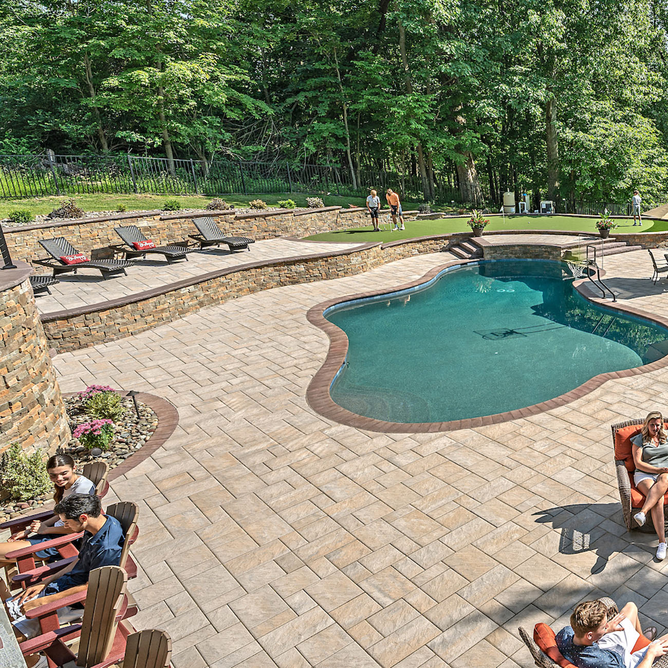 Luxury pool area with a raise patio and pool deck installed with Trilogy+ Textured Pavers