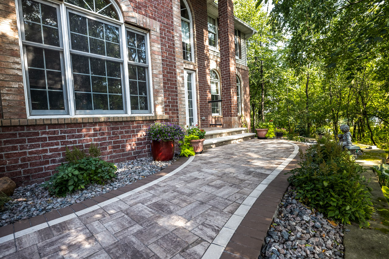 luxury brick house with a walkway to the front enterance