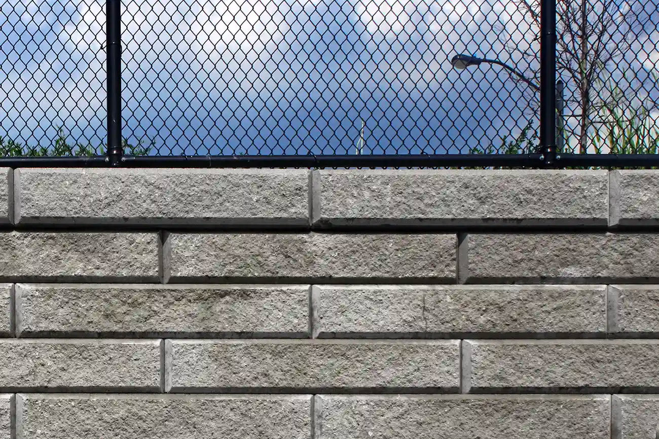 Large sterling retaining wall system with a stair way up to a house.