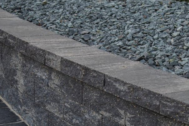 Rock Bed help back with a retaining wall capped with Tribute Smooth Wall Cap