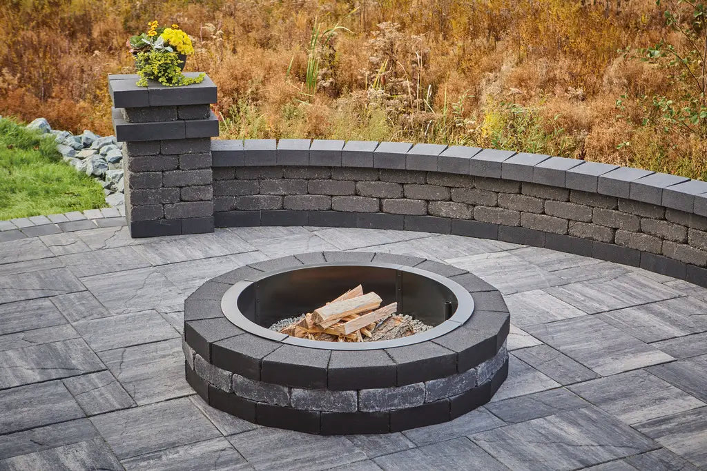 Summit Round Fire Pit on a patio in majestic and a round retaining wall.