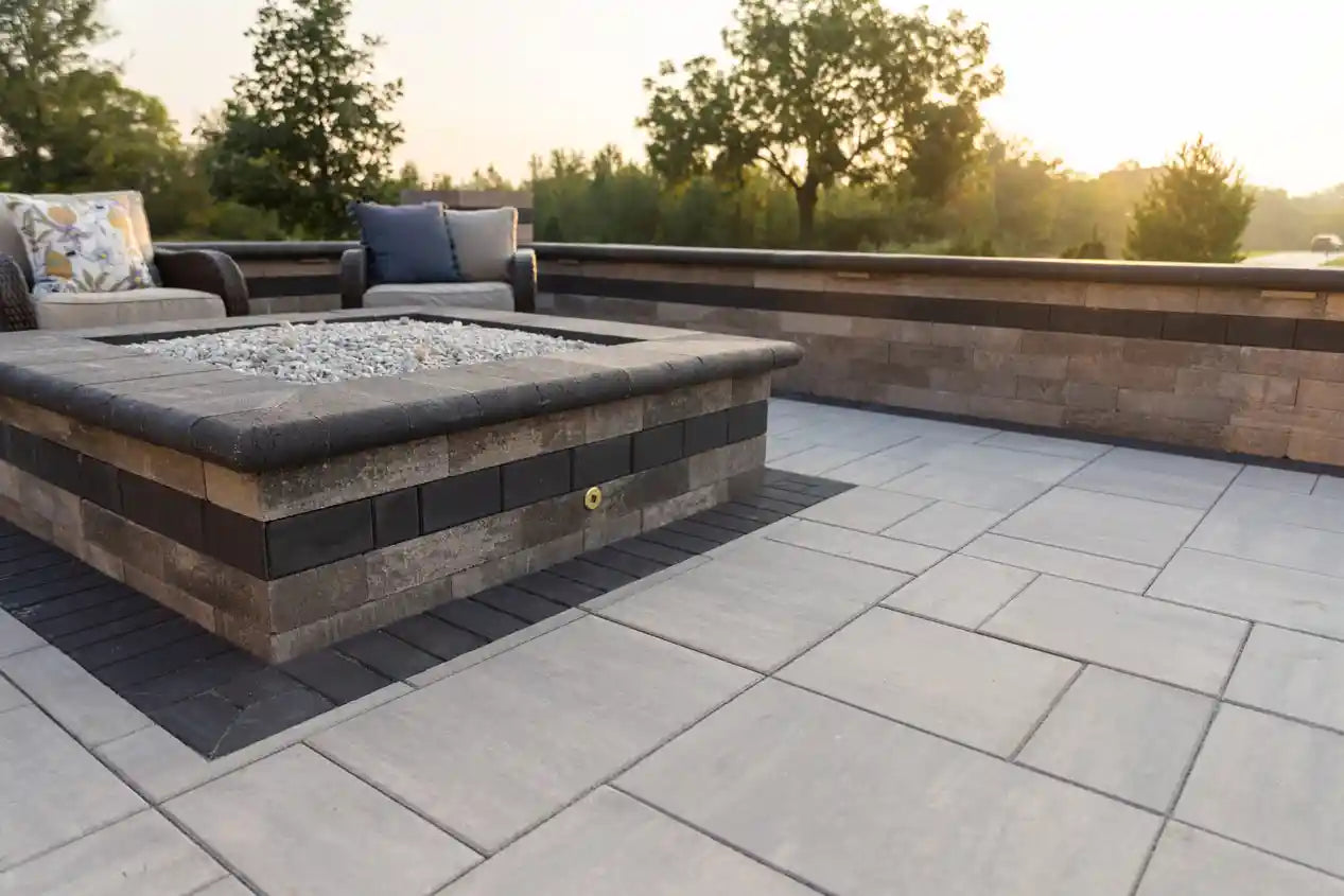 Fire pit on a patio that is surrounded by a retaining wall. Both using Grand Crest Coping on top for a finished look.