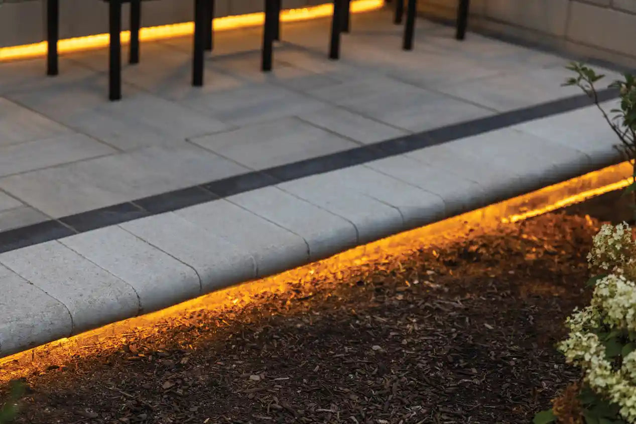 Grand Crest Coping used as a patio border with lighting underneath.
