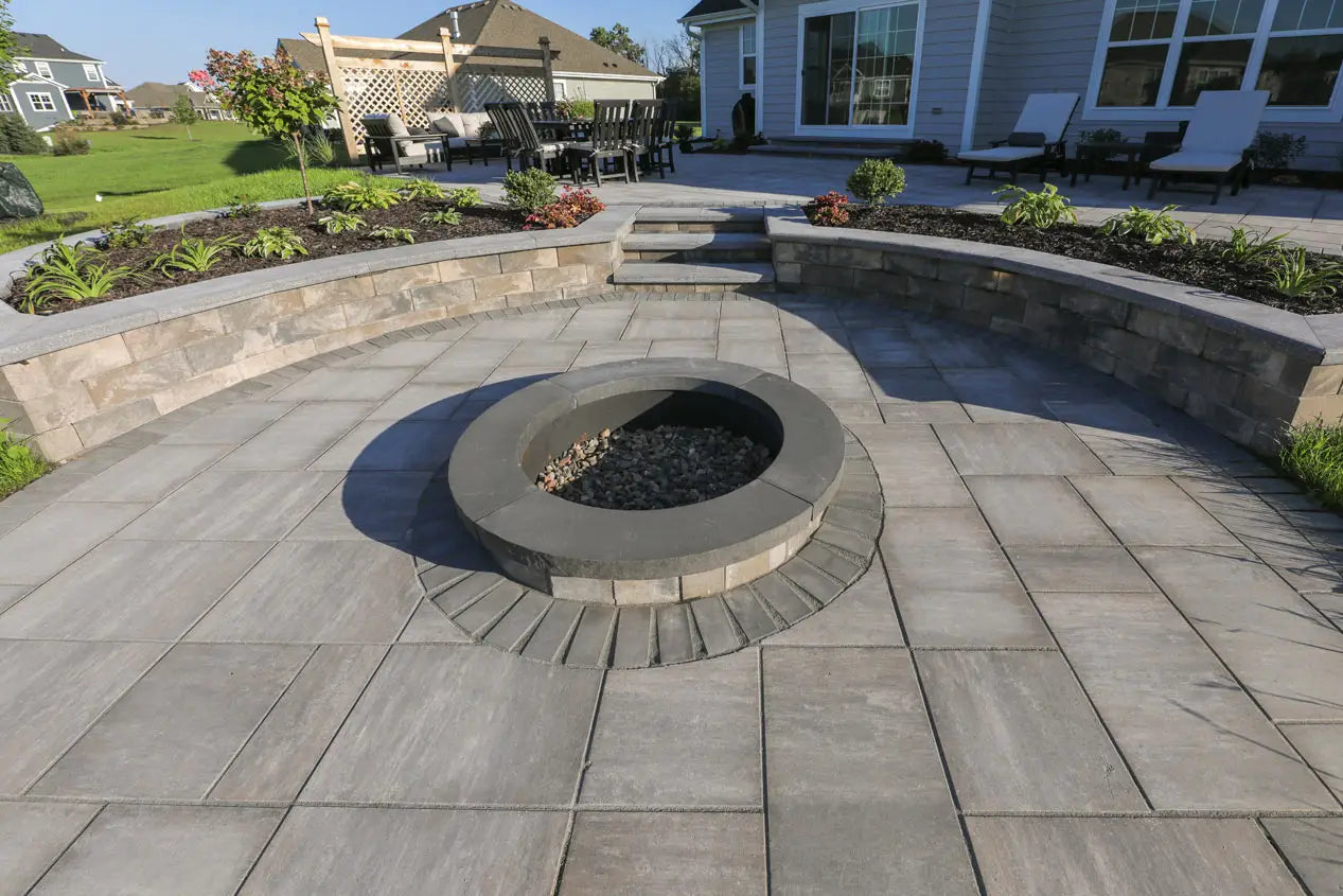Summit Round Fire Pit on a patio in timeless surrounded by retaining walls.