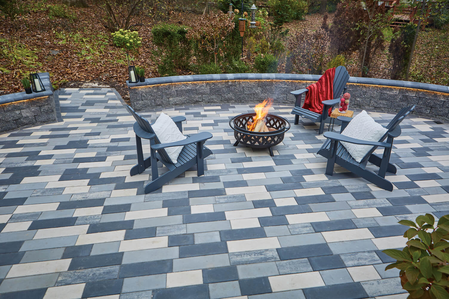 Patio built with Influence Pavers in multiple random colours with a fire pit.