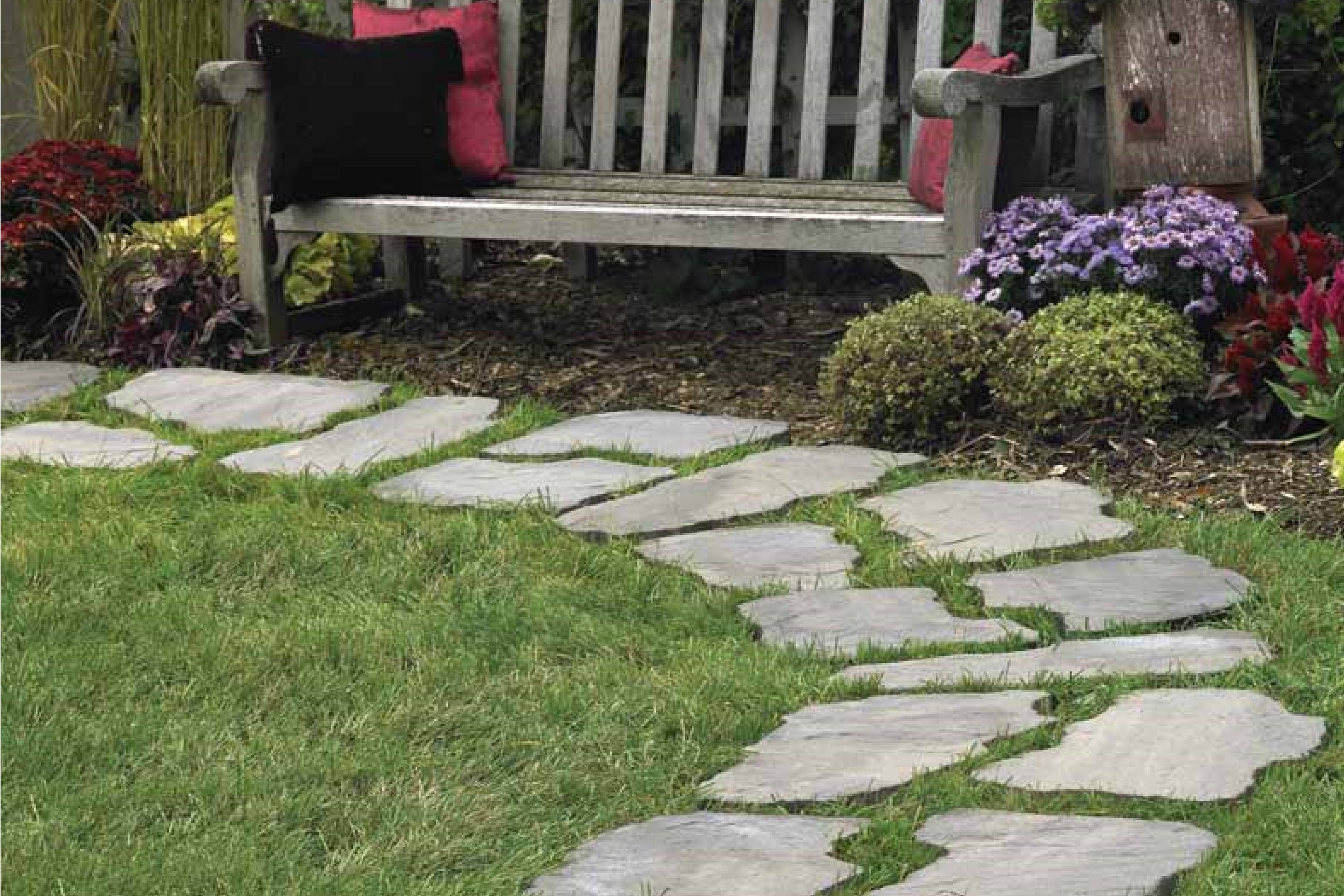 walkway made with footnotes Stepping Stones with a bench surrounded by flowers