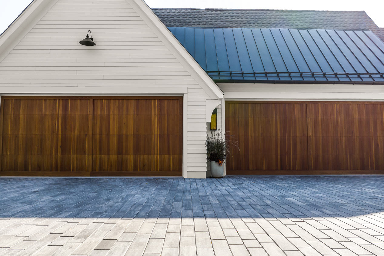 Driveway made with Influence Pavers looking at the wood garage doors