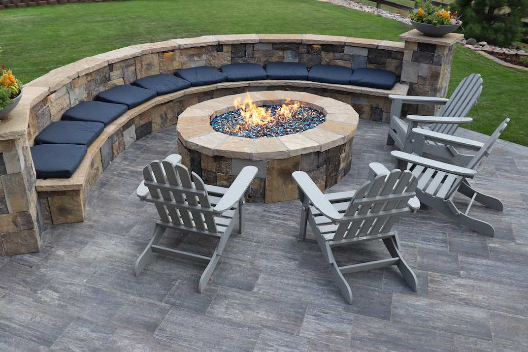 Fire pit area with retaining wall and a bench.