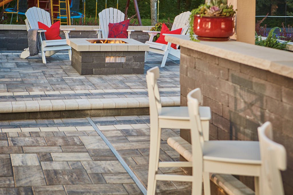 Patio made with Grand Tranquility Pavers with a outdoor bar and fire pit area.