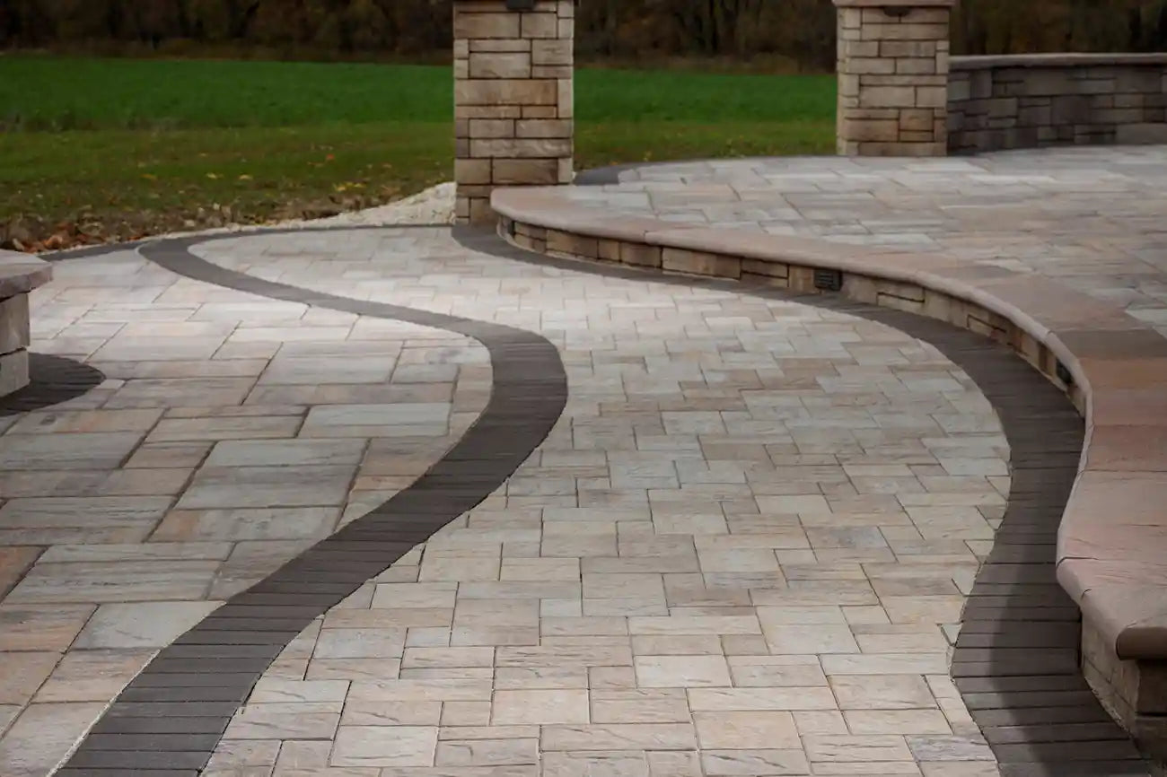 Patio made with large Origin Paver Set with a retaining wall and pavers, with 2 patio chairs.