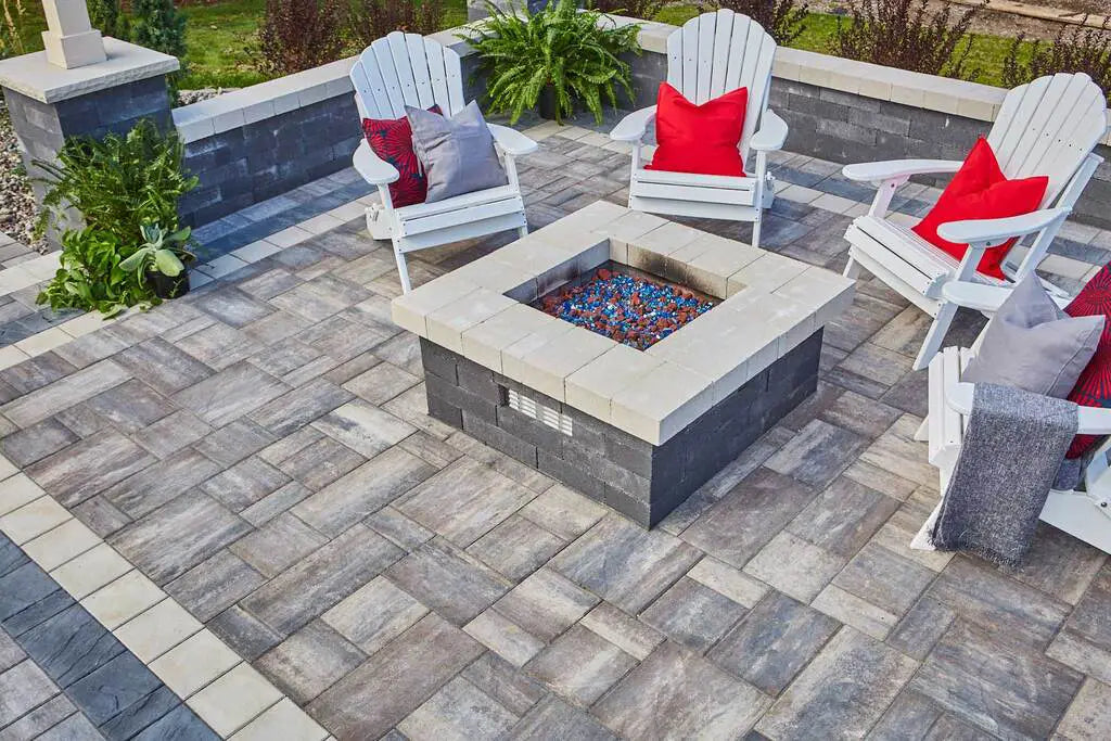 Summit Square Fire Pit on a patio in timeless and patio chairs with red pillows.