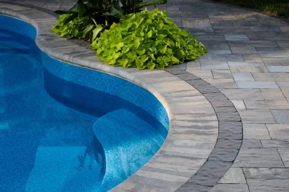 Marina Coping installed on the edge of a pool with a patio surrounding it